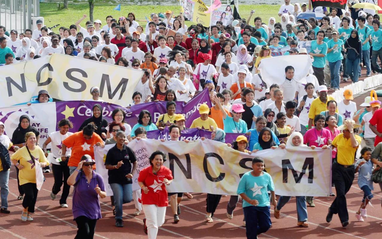 Participants walking the final lap together carrying NCSM banners