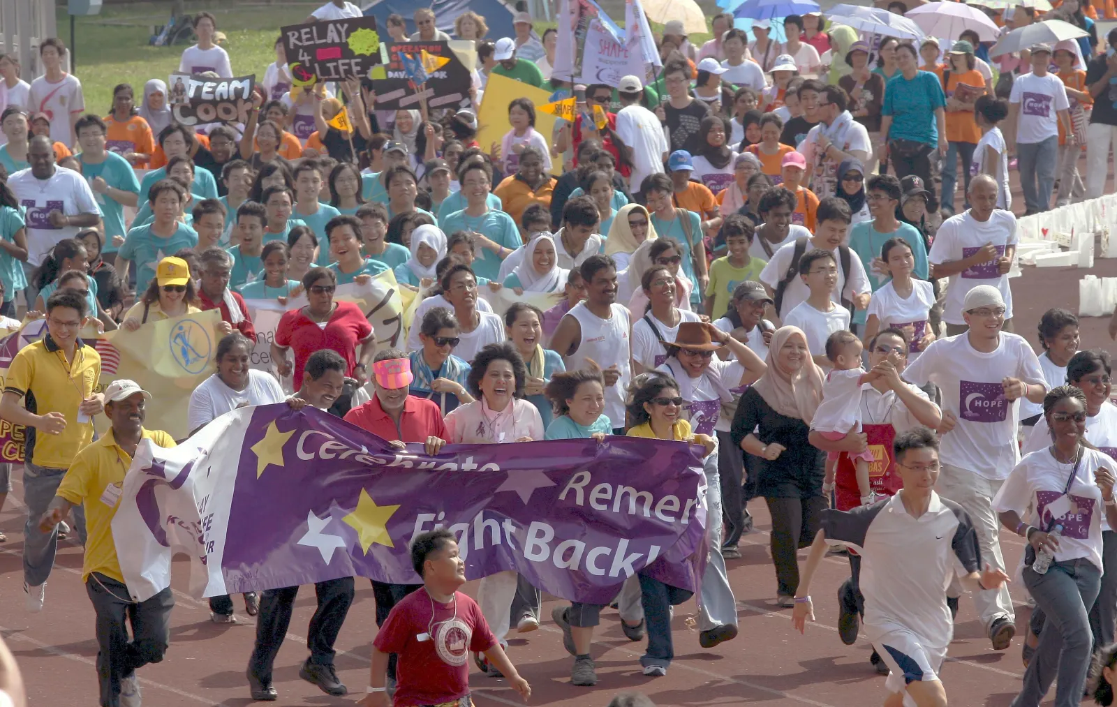 Relay For Life participants holding a banner that reads Celebrate, Remember, Fight Back