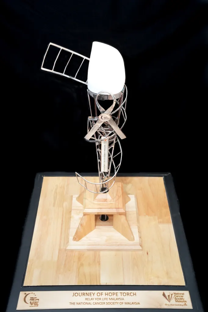 The Journey of Hope torch, a sculpted aluminium torch on a wooden stand