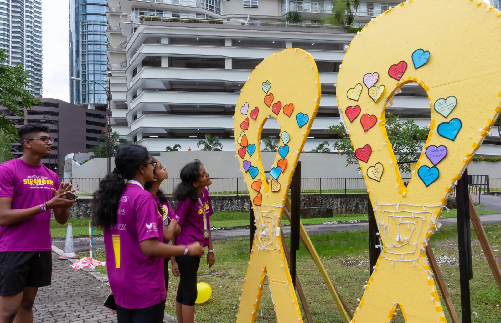 Participants at an R-Day booth with heart-shaped ribbon cut-outs